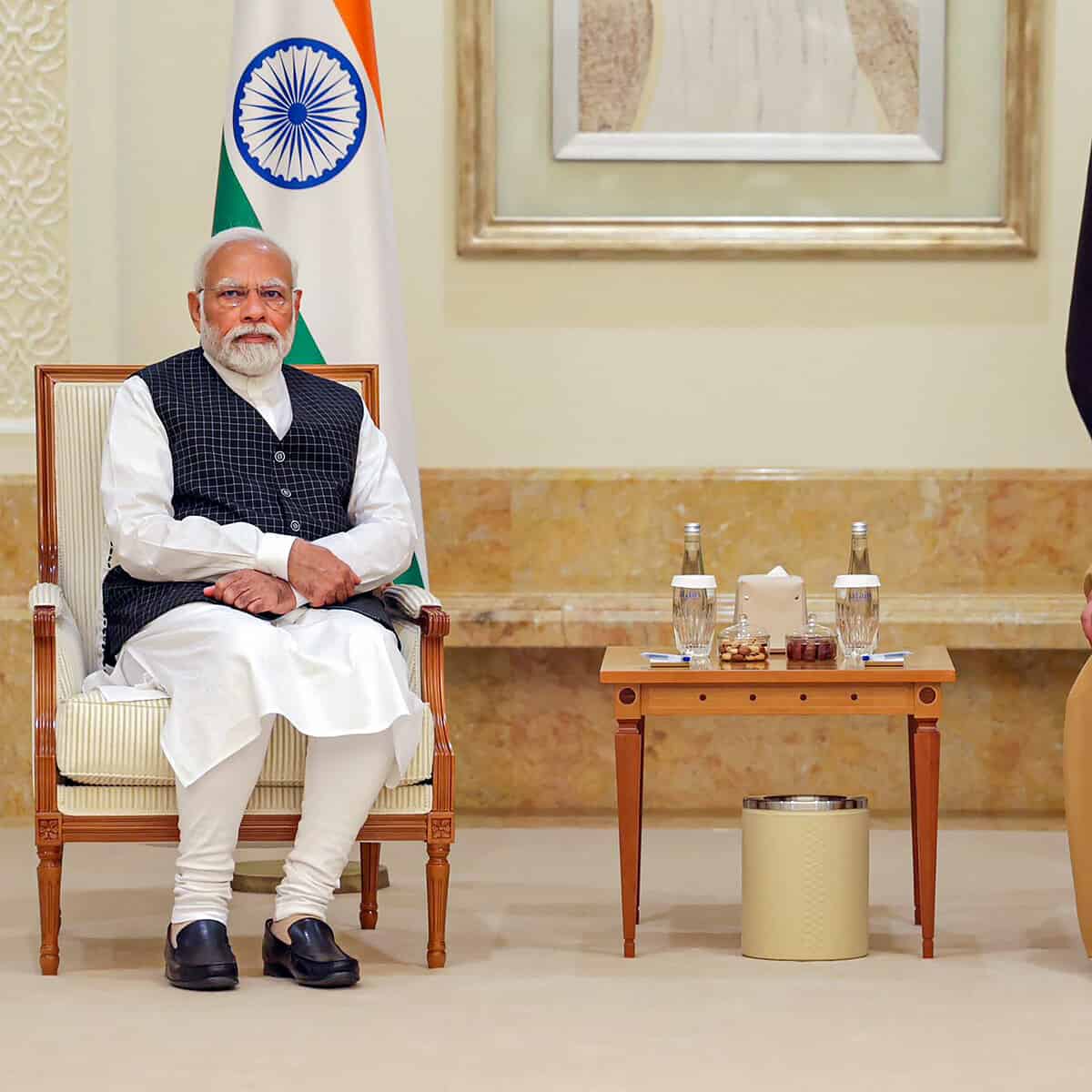 Narendra Modi seated beside the Indian flag
